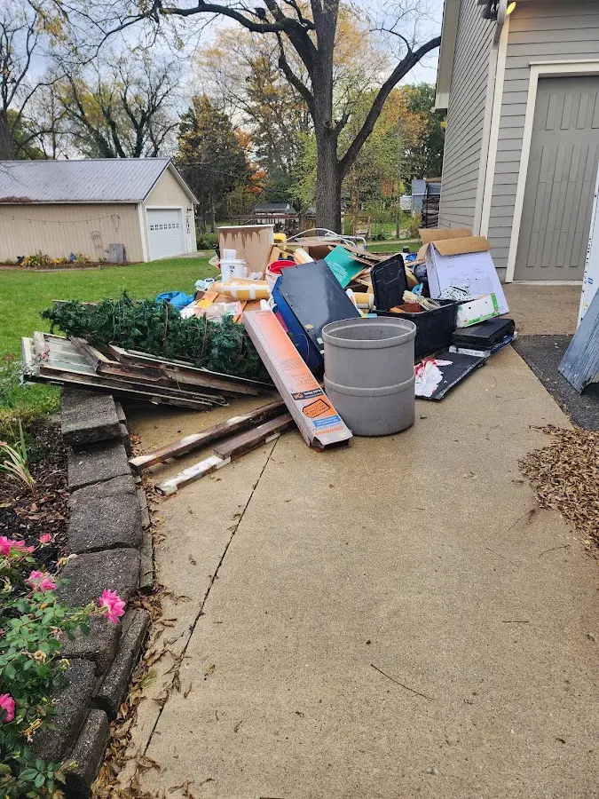 Dumpster being loaded with debris for Roofing Dumpster Rental in Pennfield